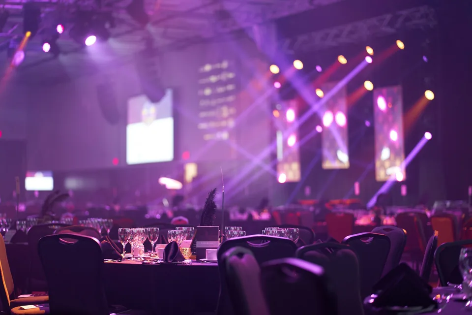 Iluminación de escenario y pantallas en una cena de empresa