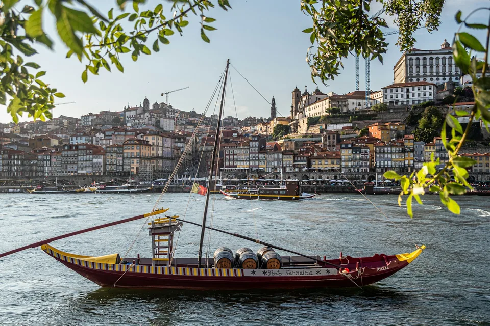 Un rabelo tradicional en el Duero, con Oporto al fondo