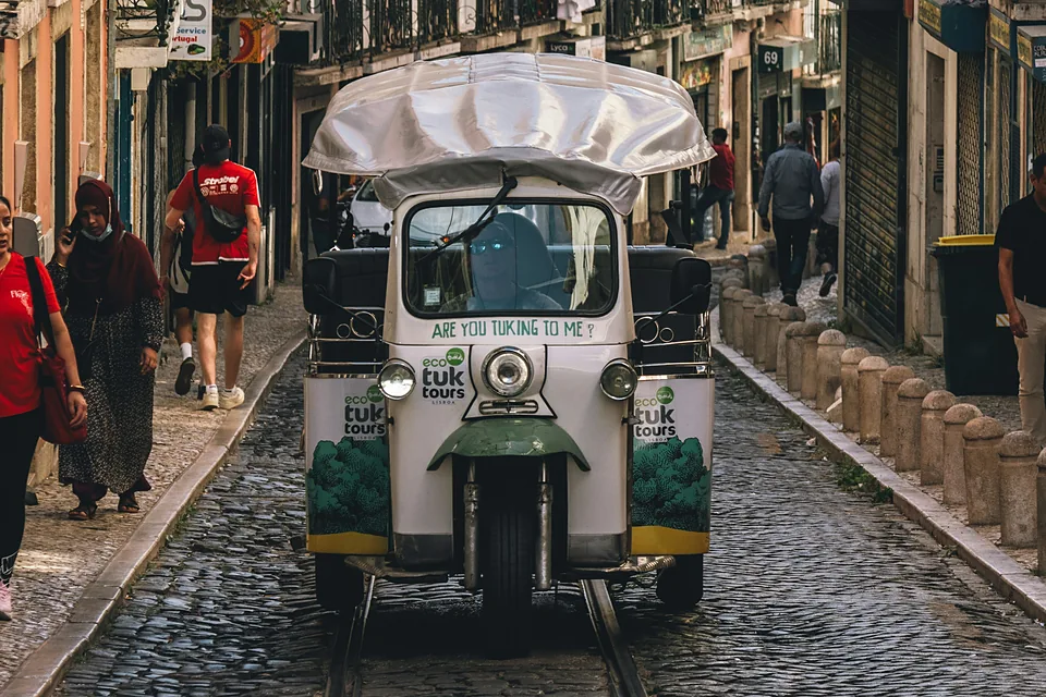Un tuk-tuk en una calle empedrada de Lisboa