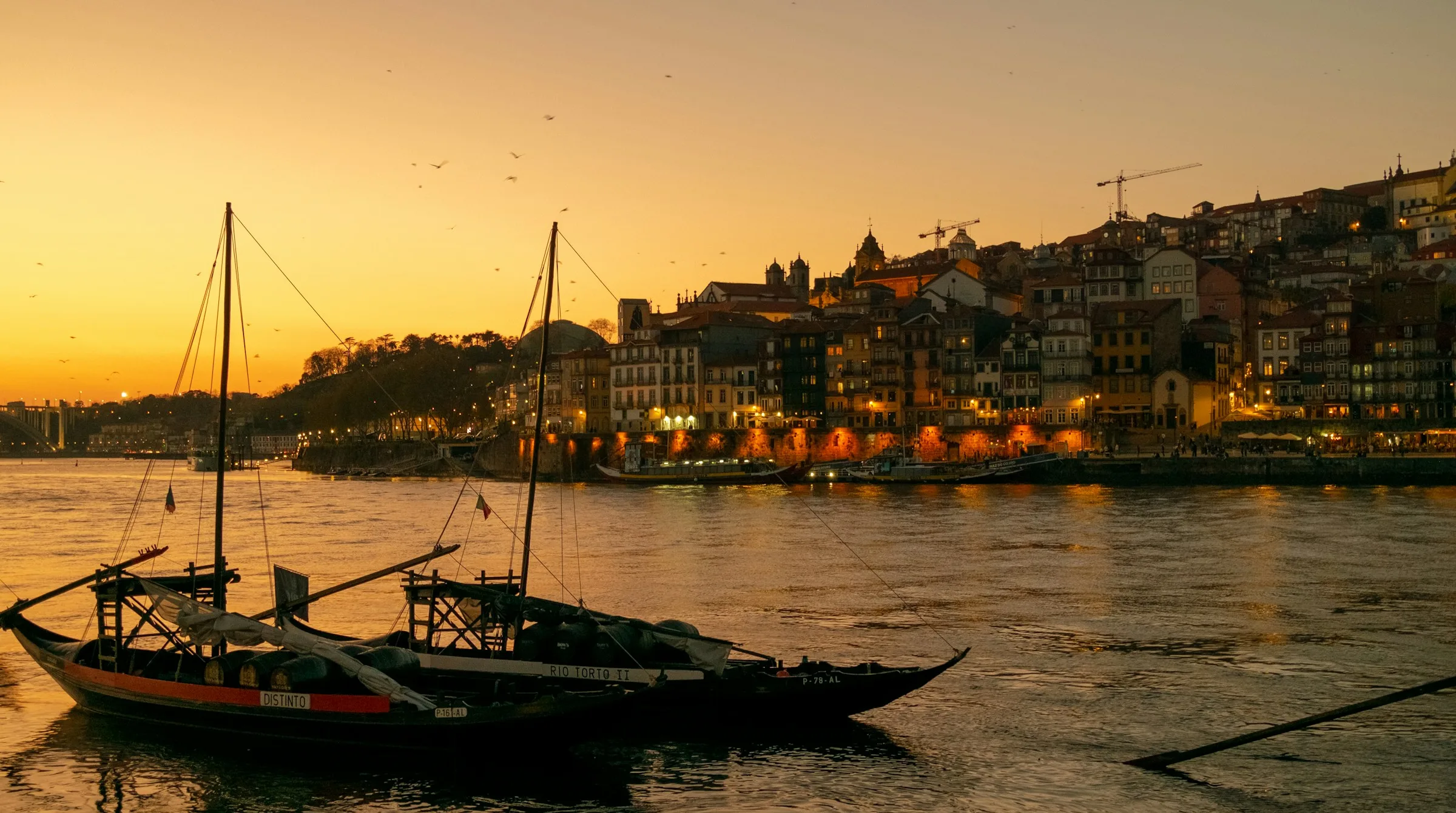 Barcos rabelos en el Duero a su paso por Oporto, al atardecer